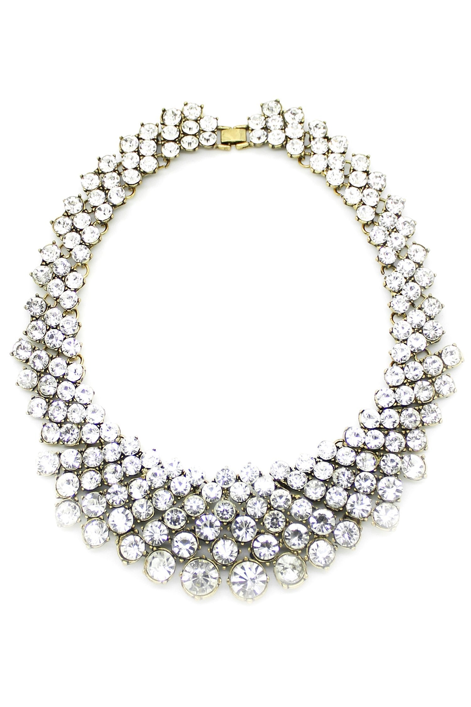 Large statement necklace with pattern of round white crystals set in gold. Measures approximately 12" in diameter and fold over clasp closure. 