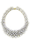 Large statement necklace with pattern of round white crystals set in gold. Measures approximately 12" in diameter and fold over clasp closure. 