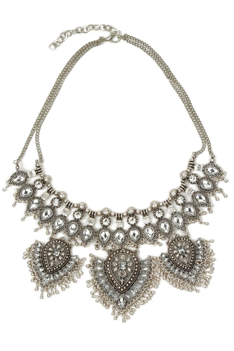 Silver tone alloy statement necklace with tribal motif design.