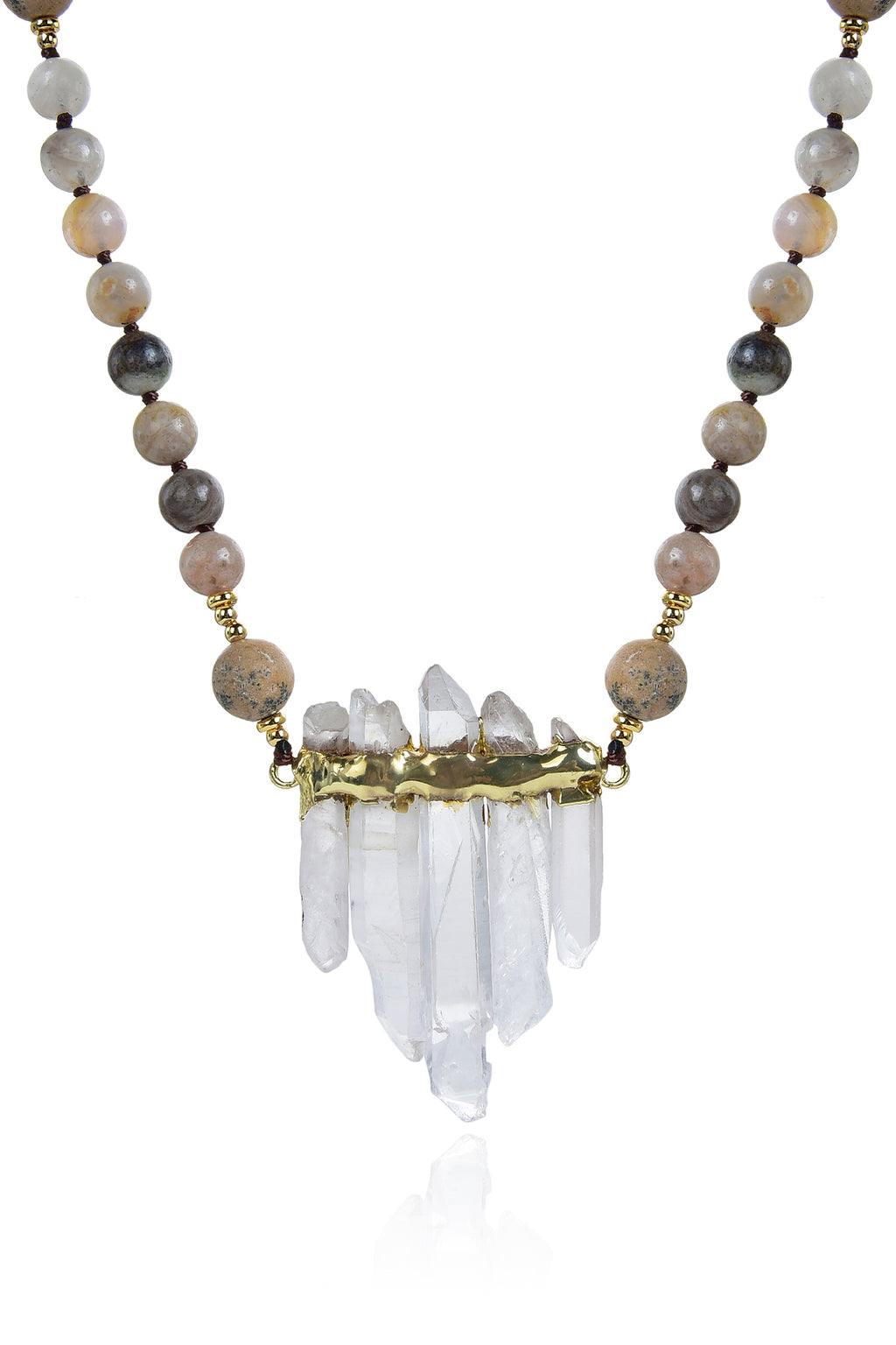 Close up view of pendant on grey agate beaded necklace. Pendant is composed of 5 quartz crystals in pyramid arrangement with gold band wrapped along top. Agate beads made of a variety of grey and brown colors compose the chain.