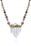 Close up view of pendant on grey agate beaded necklace. Pendant is composed of 5 quartz crystals in pyramid arrangement with gold band wrapped along top. Agate beads made of a variety of grey and brown colors compose the chain.