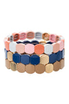 3 piece bracelet set all with rounded square enamel beads. First bracelet features pink and white beads. Second bracelet features navy blue and gold beads. Third bracelet features gold toned beads. All bracelets are stretchy.