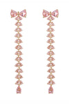 Gold tone brass bow earrings studded with pink CZ crystals.