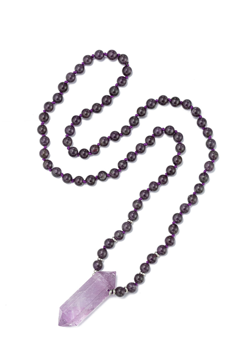 Handmade amethyst quartz crystal pendant on a beaded necklace.