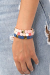 3-piece stretchy bracelet set on wrist of model. Gold beads are shiny, pink and blue beads are smooth in appearance. 